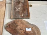 several wooden cutting boards on a table with a price tag on them