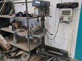 une machine qui se trouve dans un garage, à côté d'un tas de bois