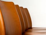 a brown leather couch sitting in front of a white wall