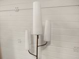 a tall candle holder with three white candles on it