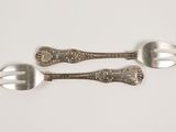 three spoons and a fork on a white surface