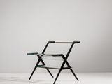 une chaise noire surmontée d'une étagère en verre