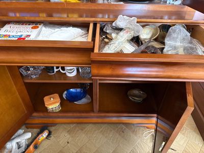 a wooden desk with a drawer full of items in it