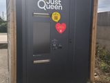a black outhouse with a red heart sticker on it