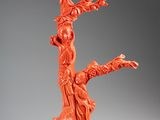 an orange figurine of a tree with a bird perched on it