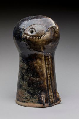 a close up of a vase with a face on it