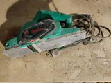 two pictures of a green circular saw on the floor