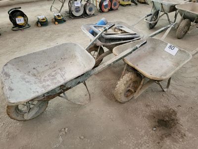 a wheelbarrow and a wheelbarrow in the middle of a dirt area