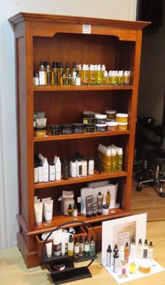 une étagère en bois sur laquelle sont posées de nombreuses bouteilles de produits cosmétiques