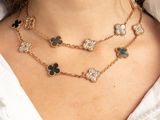 a close up of a woman wearing a white shirt and black and gold necklace