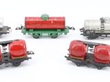 several toy train cars are lined up on a white surface
