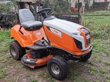 an orange riding lawn mower sitting in the grass