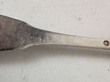 a silver spoon with a metal handle on a white surface