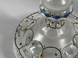 a glass candle holder with a blue and white design on it