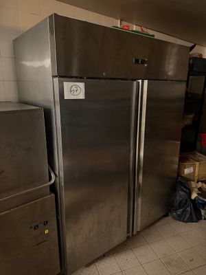 a refrigerator and freezer in a kitchen with a lot of boxes