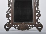 a mirror that is sitting on a stand on a white surface