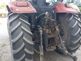 a red tractor that is parked in the dirt
