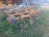 a rusted plow sitting in the middle of a field