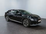 a black car is parked in a room with a white wall