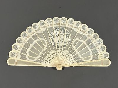 un éventail en dentelle blanche sur fond noir