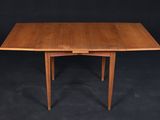 a wooden table with two leaves on the top of it