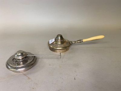un petit objet en métal muni d'un manche en bois, posé sur une table