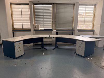 un bureau d'angle dans un bureau vide avec de nombreuses fenêtres