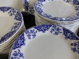 a lot of blue and white plates stacked on top of each other