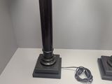 two lamps on a white table with a cord plugged into the base