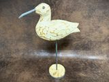 a small bird that is standing on a wooden stand