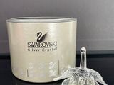 figurine de cygne en cristal à côté d'un bougeoir Swarovski