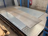 steel plate in a warehouse with boxes and pallets in the background