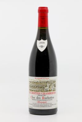 une bouteille de vin rouge posée sur une table blanche