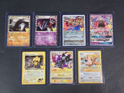 Plusieurs cartes Pokémon sont alignées sur une surface noire