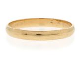 a close up of a gold wedding ring on a white background