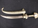 pair of antique indian dagger with brass fittings on a black background