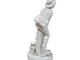 a white statue of a man with a hat and a bucket