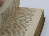 a person holding a book open on a table