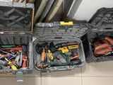 de nombreux outils différents rangés dans une mallette posée par terre