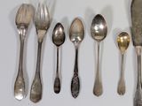 several spoons, forks, and knives are lined up on a table