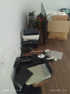 un bureau sur lequel se trouvent un ordinateur portable, une imprimante et d'autres objets