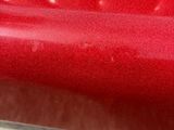 a close up view of a red car ' s paint job