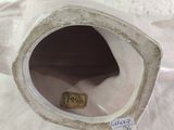 a close up of a white vase with a tag on it