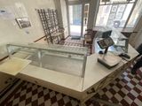 un homme debout devant un comptoir, face à une vitrine en verre