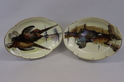 deux assiettes avec des oiseaux peints dessus, posées sur une table