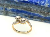 un gros plan d'une bague en diamant et en or posée sur une pierre bleue