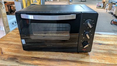 un four grille-pain noir posé sur une table en bois