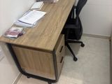 un bureau avec une chaise et un ordinateur posé dessus, dans une petite pièce