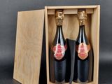 two bottles of wine in a wooden box on a table