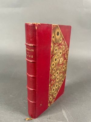 un vieux livre rouge avec un motif doré sur la couverture